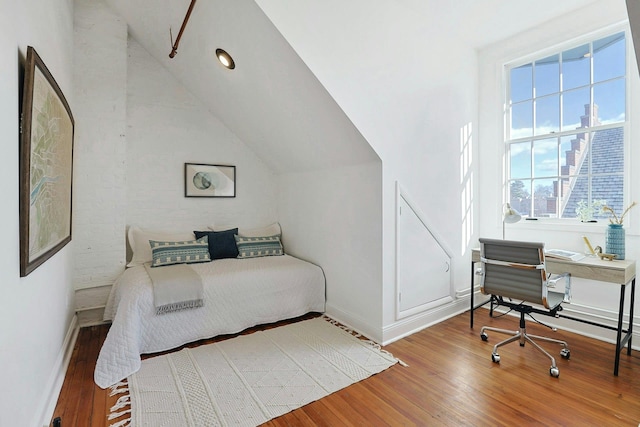 bedroom with lofted ceiling and hardwood / wood-style floors