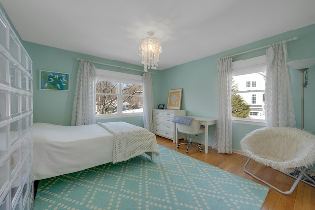 bedroom featuring an inviting chandelier and hardwood / wood-style floors