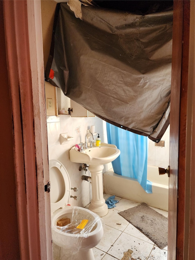 bathroom with tile patterned floors, toilet, and shower / tub combo