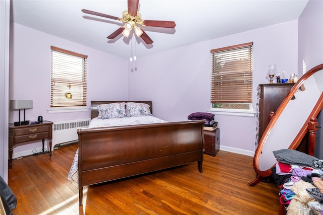 bedroom featuring dark hardwood / wood-style flooring, radiator, and ceiling fan