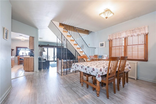 dining area featuring hardwood / wood-style flooring and radiator heating unit