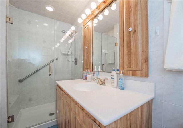 bathroom featuring vanity, tile walls, and walk in shower