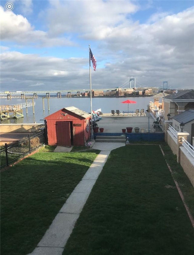 view of yard featuring a water view and a storage unit