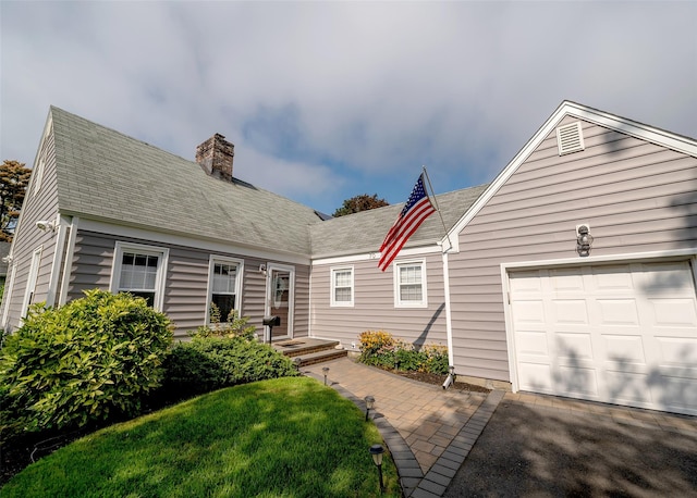 cape cod-style house with a front lawn and a garage