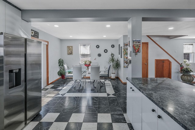 kitchen with white cabinets, dark stone counters, and stainless steel refrigerator with ice dispenser