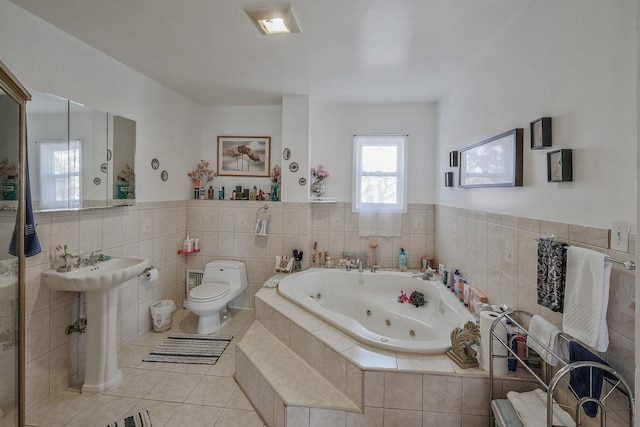 bathroom featuring toilet, tiled bath, and tile patterned floors