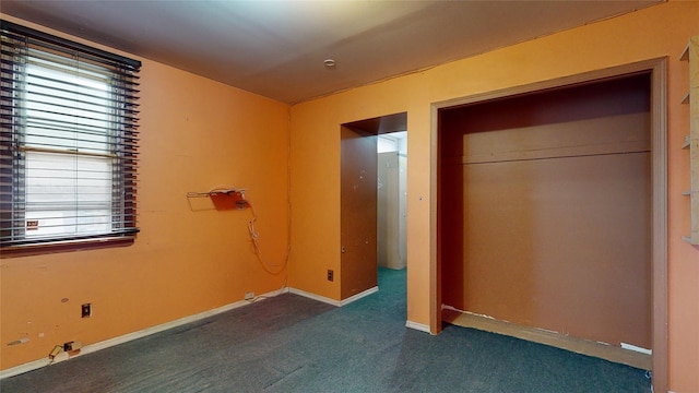 unfurnished bedroom featuring a closet and dark carpet