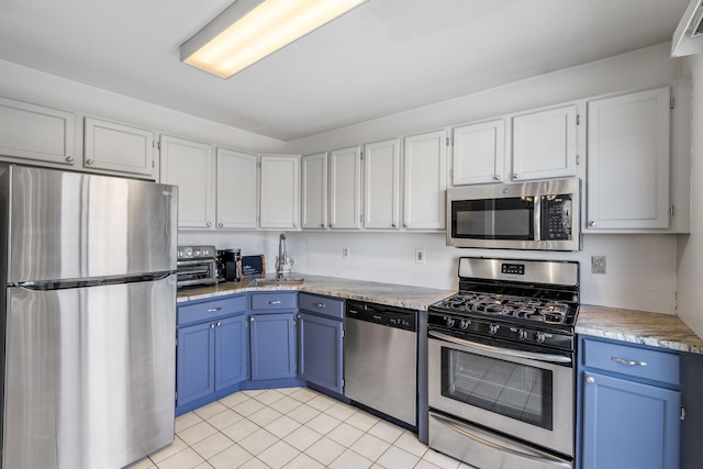 kitchen featuring white cabinets, stainless steel appliances, blue cabinets, and sink