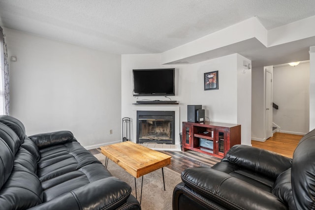 living room featuring a textured ceiling and wood-type flooring