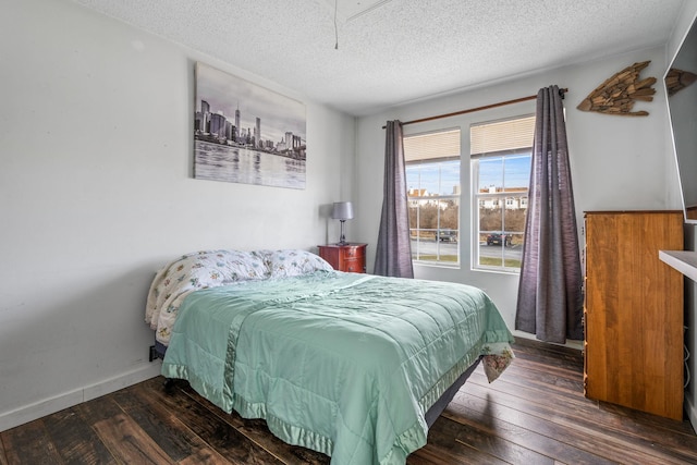 bedroom featuring a textured ceiling and dark hardwood / wood-style floors