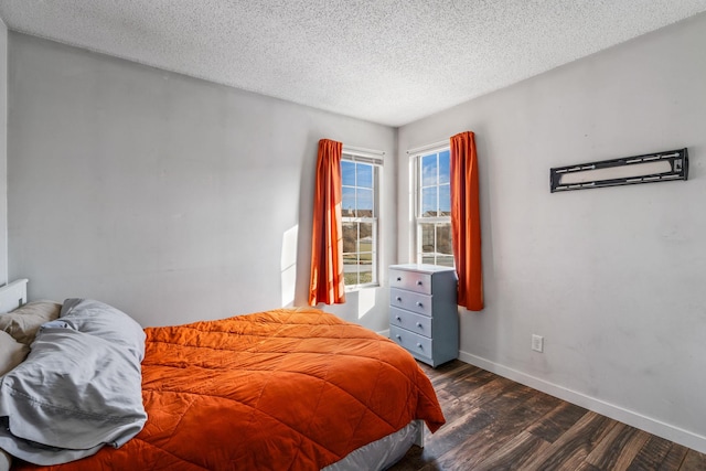 bedroom featuring a textured ceiling and dark hardwood / wood-style floors