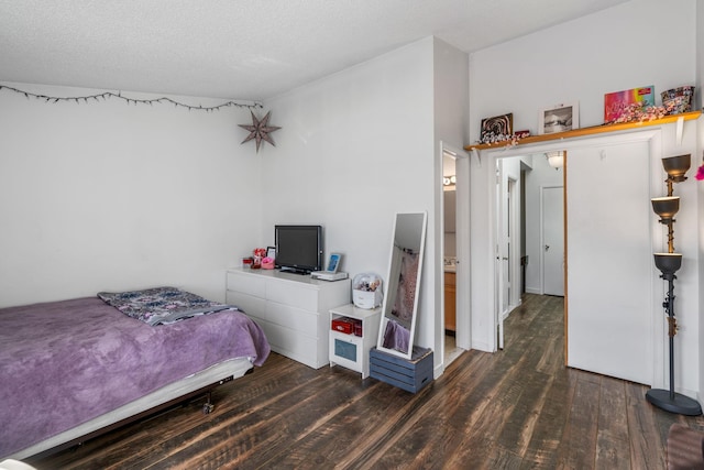 bedroom featuring a textured ceiling and dark hardwood / wood-style floors