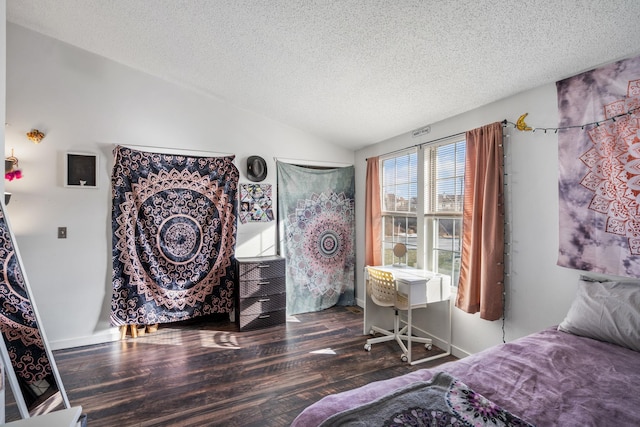 bedroom with lofted ceiling, a textured ceiling, and dark wood-type flooring