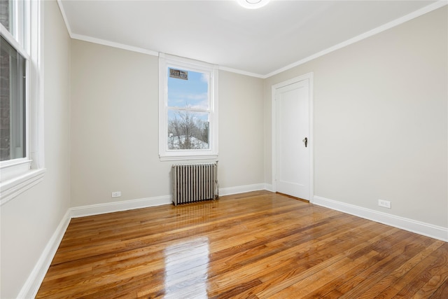 unfurnished room featuring radiator, light hardwood / wood-style flooring, and ornamental molding