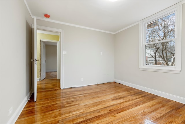 empty room featuring light hardwood / wood-style floors and ornamental molding