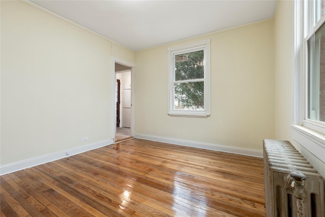 unfurnished room with radiator heating unit and light hardwood / wood-style floors