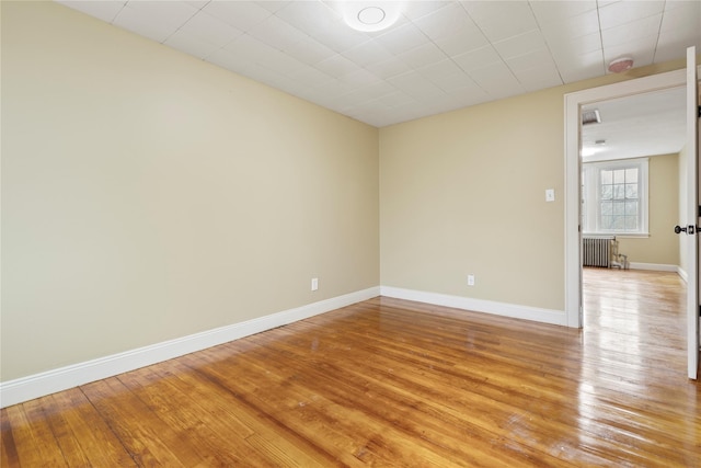 unfurnished room featuring light wood-type flooring and radiator