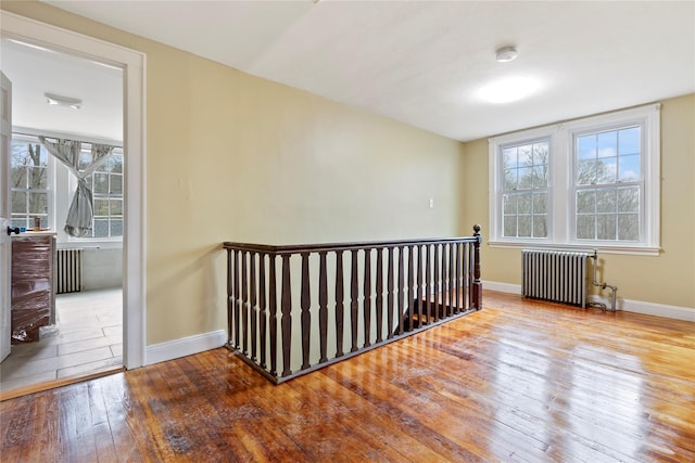 spare room featuring hardwood / wood-style floors, a wealth of natural light, and radiator