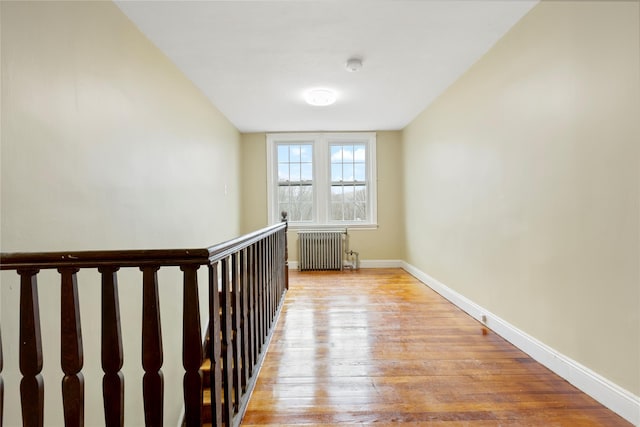 hallway featuring radiator heating unit and light wood-type flooring