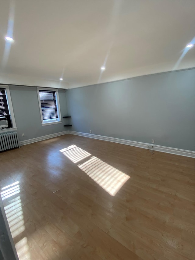 unfurnished room featuring light hardwood / wood-style floors and radiator