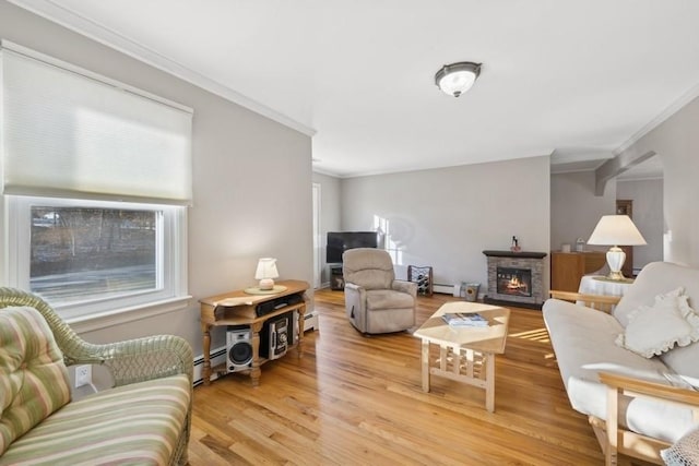 living room featuring light hardwood / wood-style floors, a stone fireplace, baseboard heating, and ornamental molding