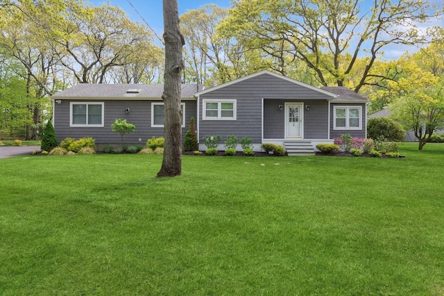 ranch-style house featuring a front yard and roof with shingles