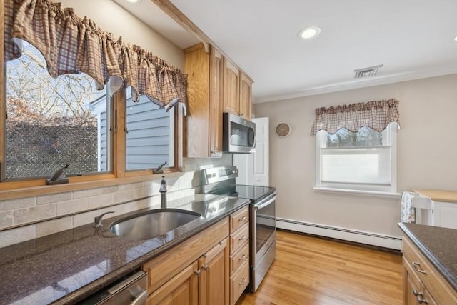 kitchen featuring stainless steel appliances, a baseboard heating unit, dark stone counters, tasteful backsplash, and crown molding