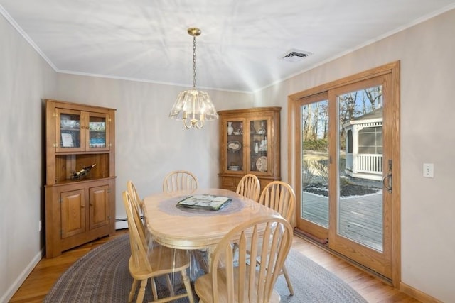 dining space featuring a chandelier, crown molding, visible vents, and light wood-style floors