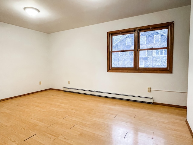 spare room featuring light hardwood / wood-style floors and a baseboard heating unit