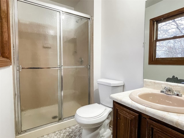 bathroom featuring vanity, toilet, and a shower with shower door