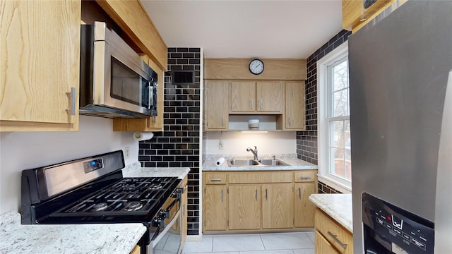 kitchen featuring light tile patterned flooring, appliances with stainless steel finishes, light brown cabinetry, and sink