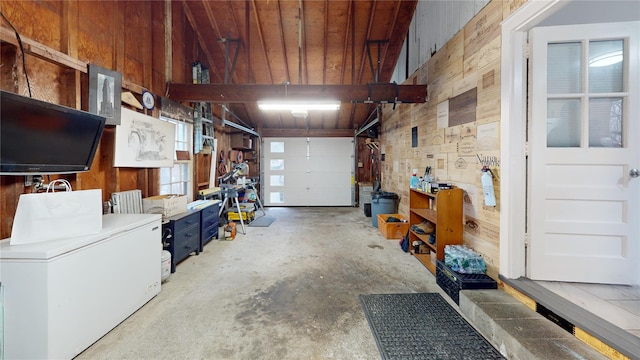 garage with wooden walls and refrigerator