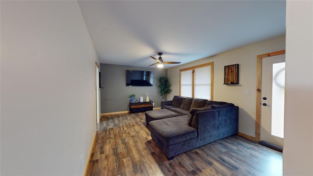 living room featuring ceiling fan and dark hardwood / wood-style floors