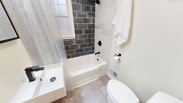 bathroom with toilet and tiled shower / bath