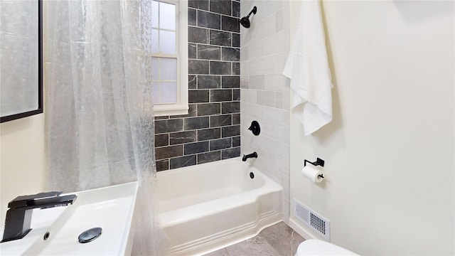 bathroom with tiled shower / bath combo and tile patterned flooring