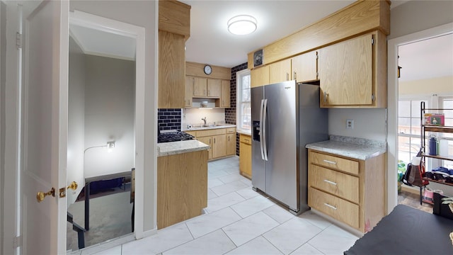 kitchen with sink, stainless steel fridge, decorative backsplash, light tile patterned floors, and light brown cabinets