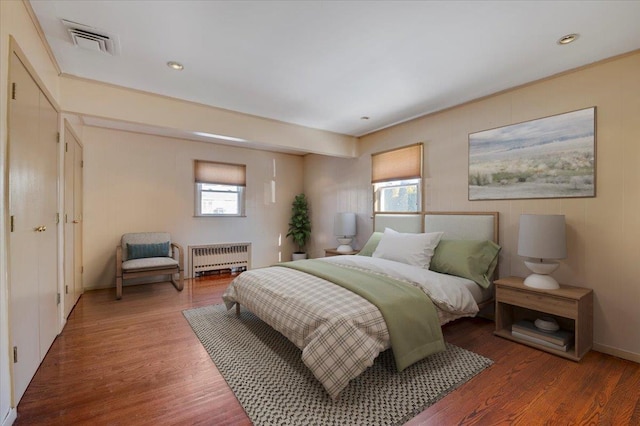 bedroom featuring radiator heating unit and hardwood / wood-style floors