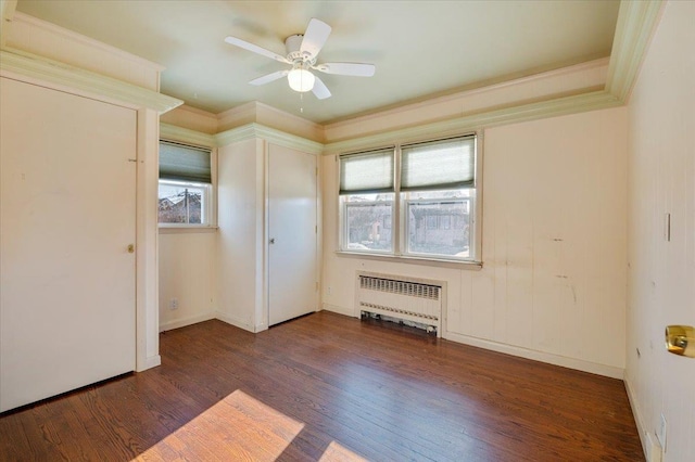 unfurnished bedroom with dark hardwood / wood-style flooring, ceiling fan, radiator heating unit, and crown molding