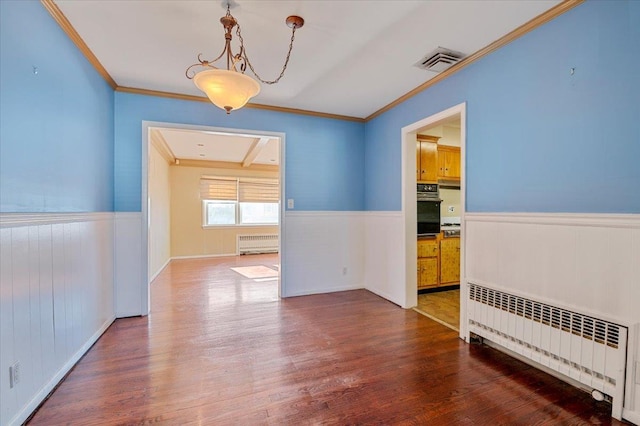 unfurnished room featuring wood-type flooring, radiator, and ornamental molding