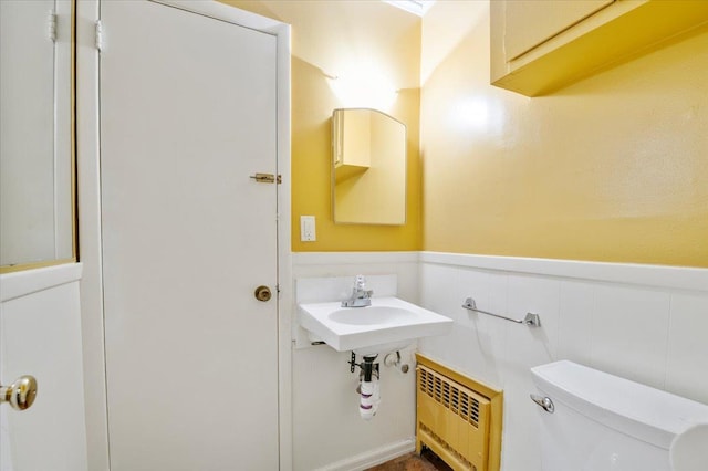 bathroom with radiator heating unit, toilet, and sink