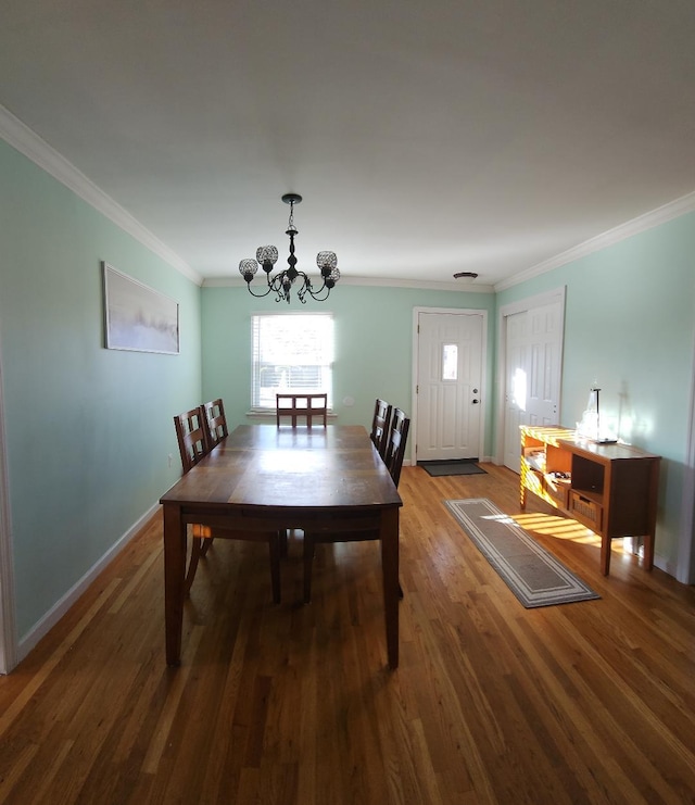 dining room featuring dark hardwood / wood-style floors, ornamental molding, and an inviting chandelier