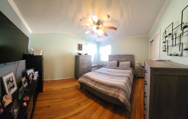 bedroom with vaulted ceiling, light hardwood / wood-style flooring, ceiling fan, and ornamental molding