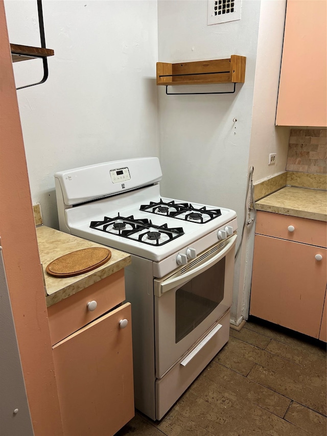 kitchen with backsplash and white gas range