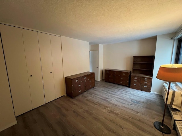 unfurnished bedroom with dark wood-type flooring and a textured ceiling