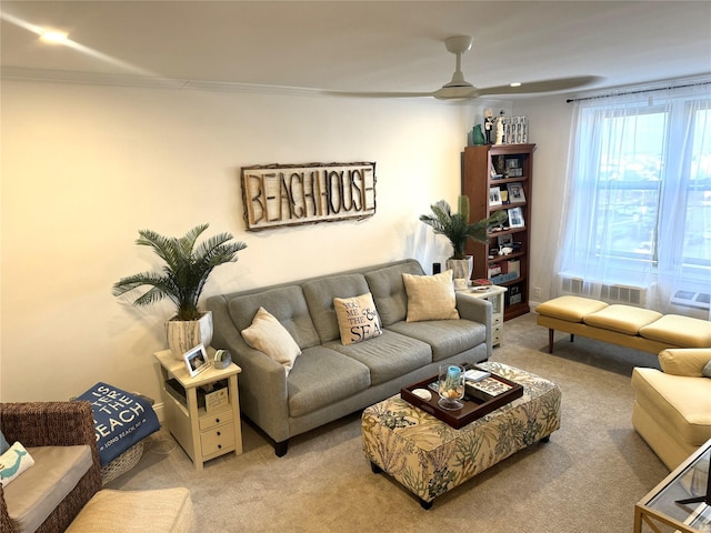 carpeted living room with ceiling fan and ornamental molding