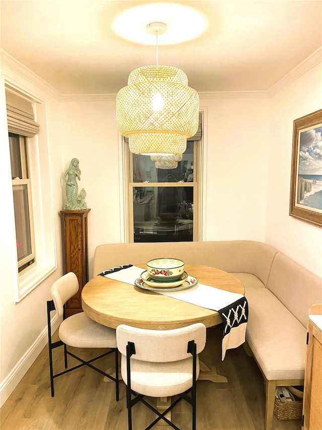 dining area with breakfast area, crown molding, and wood-type flooring