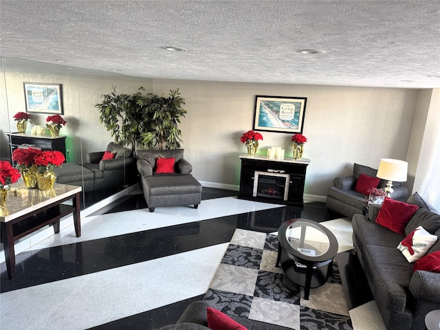 living room featuring a textured ceiling and a fireplace