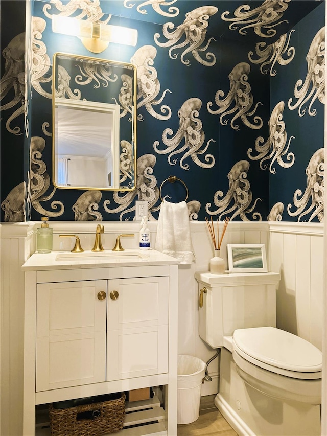 bathroom featuring wood finished floors, toilet, and vanity