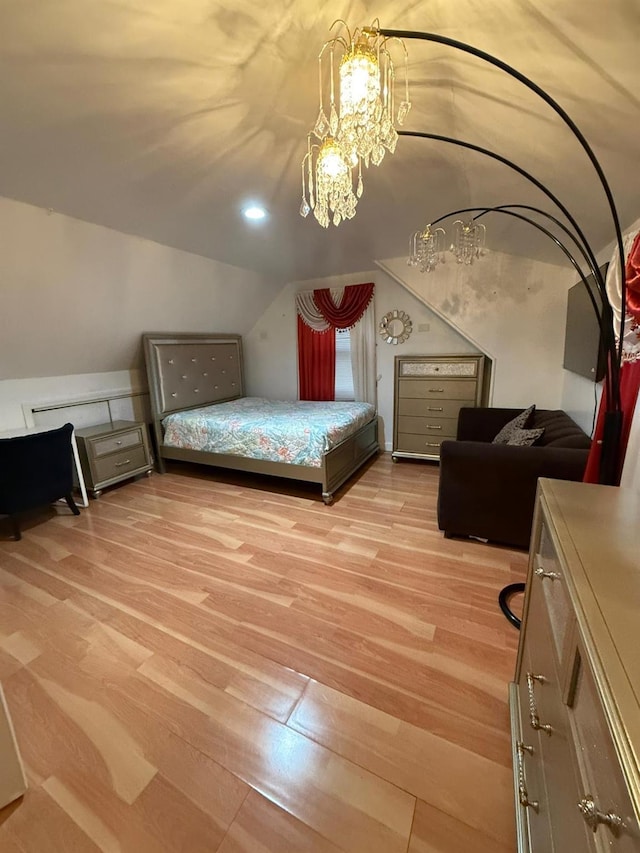 bedroom with lofted ceiling, light wood-type flooring, and a notable chandelier