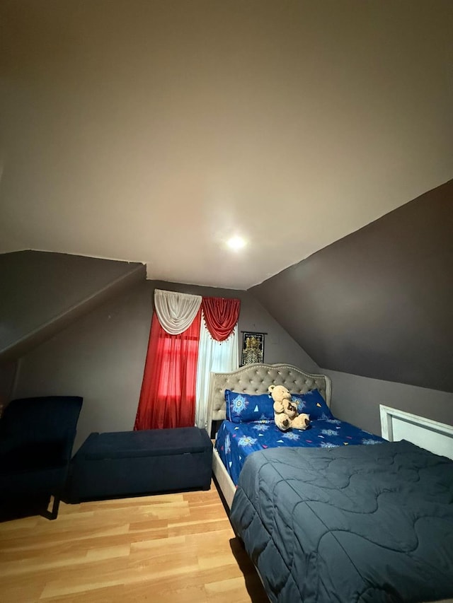 bedroom featuring hardwood / wood-style floors and vaulted ceiling